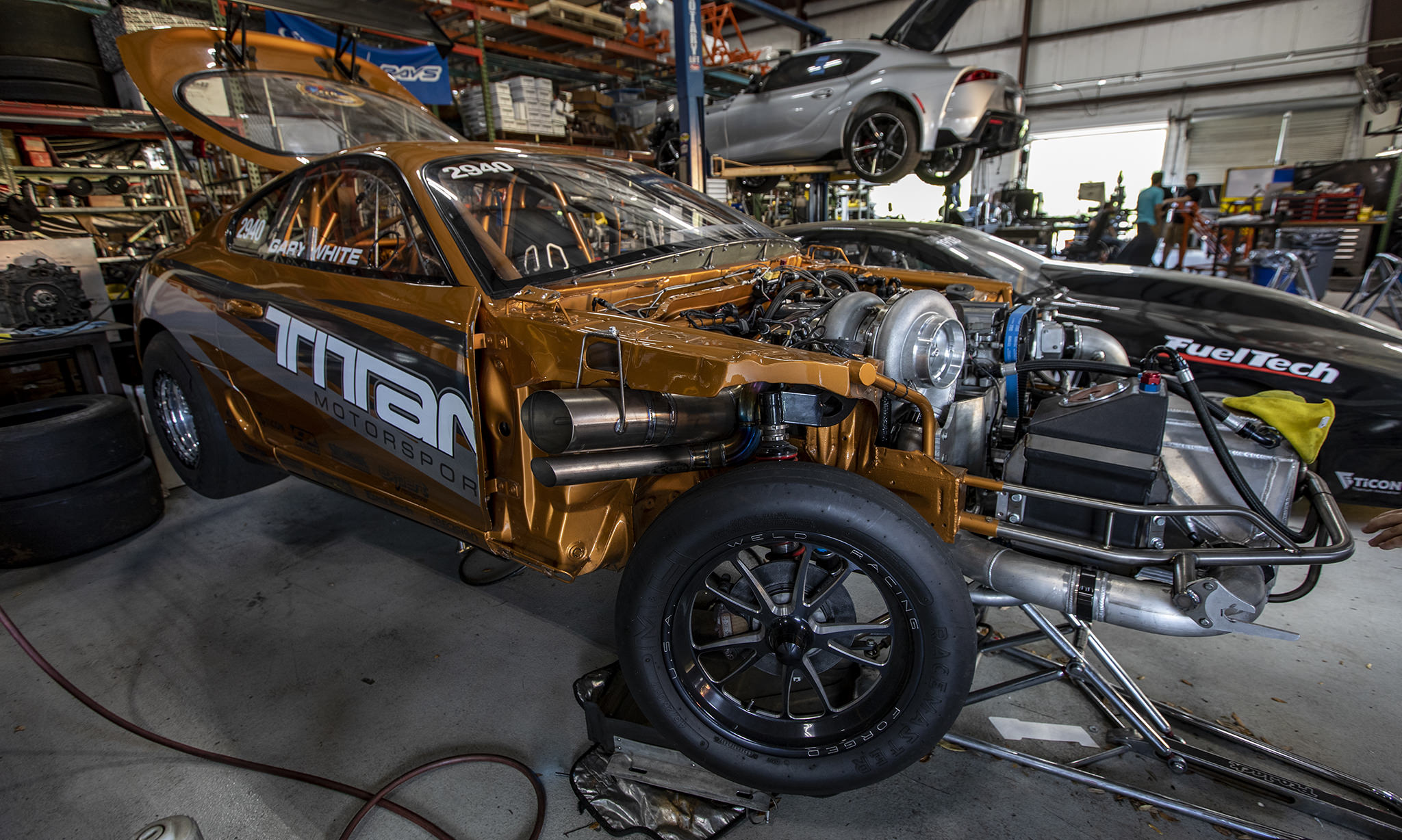 toyota supra dourado recebendo modificações extremas em uma oficina