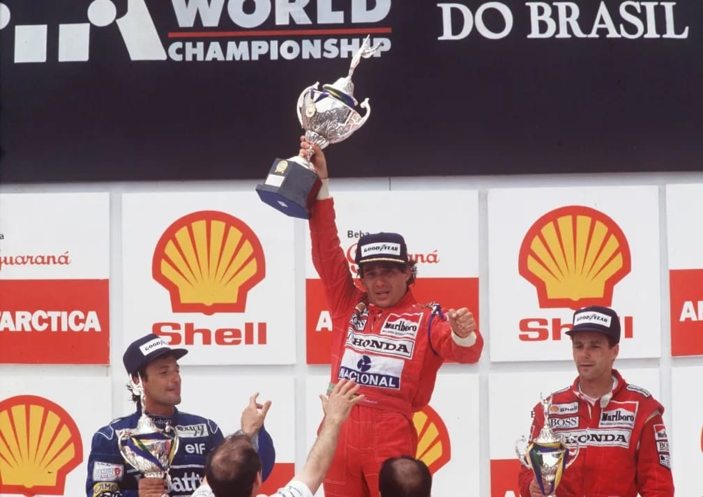 Ayrton Senna emocionado e exausto no pódio após vencer o GP do Brasil de 1991 em Interlagos.