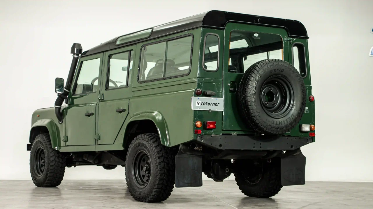 Traseira e lateral do Land Rover Defender 110 quatro portas verde com estepe na tampa