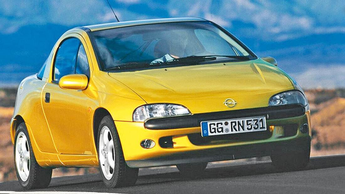 Opel Tigra Amarelo no asfalto com piloto