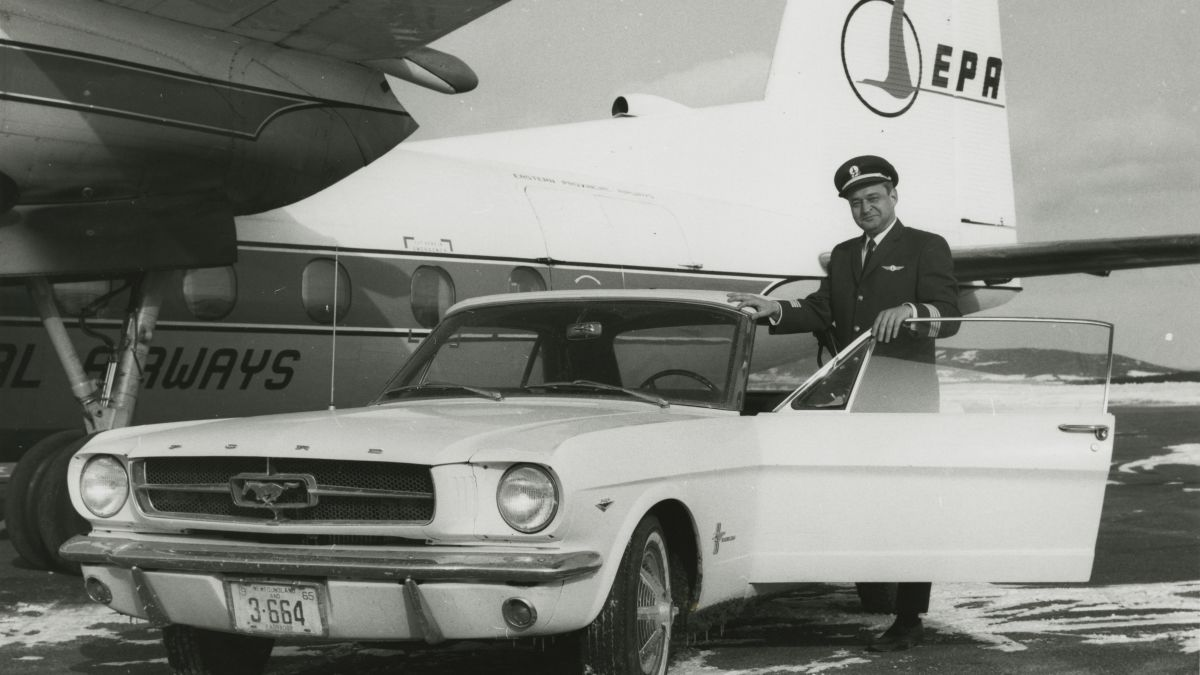 ford mustang ao lado de um piloto e na frende de um avião
